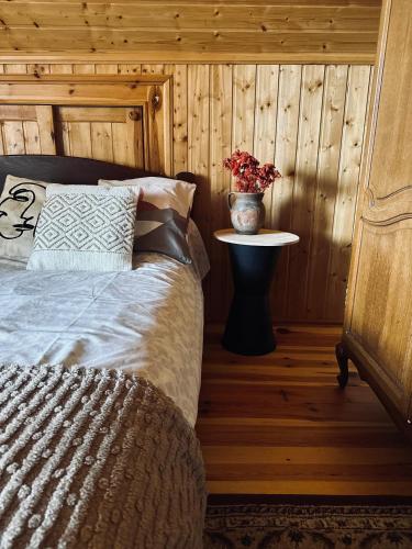 a bedroom with a bed and a vase of flowers on a table at ROZTOCZE u ALEKSA SUSIEC - JACUZII , GORĄCA BALIA!!! in Susiec