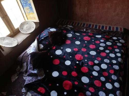 a bed with polka dots on it in a bedroom at Volunteer in desert in Mhamid