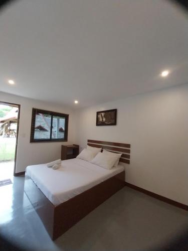 a bedroom with a bed with white sheets and pillows at Loboc Nipa Huts Cottages Rental in Camisan
