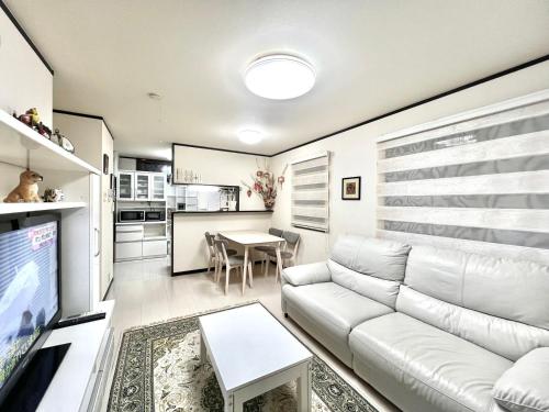 a living room with a white couch and a table at 4mins to Station 4 Lines for used Direct to Shinjuku Ikebukuro every spots Big House Family 3 Bedrooms Max for 8 people in Tokyo