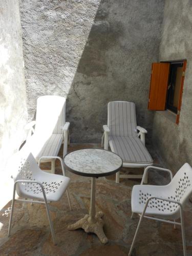 un groupe de chaises, une table et des chaises dans l'établissement Adorable meublé de standing dans chalet montagnard, à Luchon