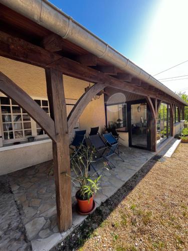 une terrasse couverte avec 2 chaises et une maison dans l'établissement Maison de famille chaleureuse, à Bassillac