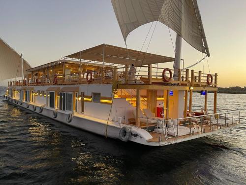 un barco que está sentado en el agua en Dahabiya Nile Sailing - Mondays 4 Nights from Luxor - Fridays 3 Nights from Aswan, en Luxor