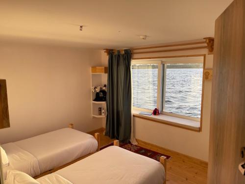 een slaapkamer met 2 bedden en een raam bij Dahabiya Nile Sailing - Mondays 4 Nights from Luxor - Fridays 3 Nights from Aswan in Luxor