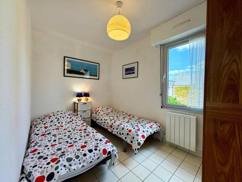 2 camas individuais num quarto com uma janela em Appartement Carnac, 2 pièces, 4 personnes - FR-1-377-15 em Carnac