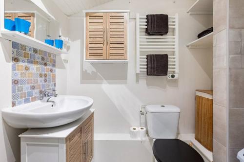ein weißes Bad mit einem Waschbecken und einem WC in der Unterkunft Studio Au coeur de la baie in Berck-sur-Mer