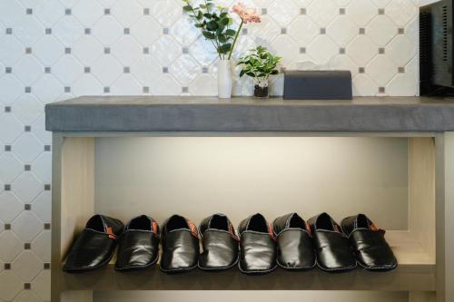 a row of shoes on a shelf under a table at LN15 RICCA 三宮5分! 屋上バーベキュー可能!キッチン付パーティ向コンド roof top BBQ in Kobe