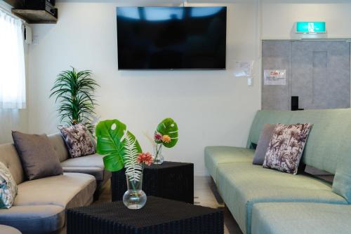 a living room with two couches and a tv at LN15 RICCA 三宮5分! 屋上バーベキュー可能!キッチン付パーティ向コンド roof top BBQ in Kobe