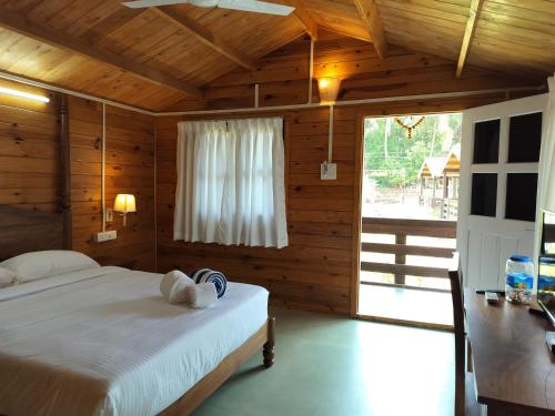 a bedroom with a bed in a wooden room at B R Cottages, 200 meters from Patnem Beach in Canacona