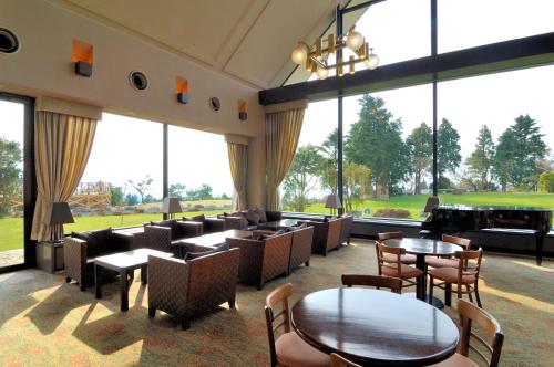 伊豆市にあるホテルハーヴェスト 天城高原のテーブルと椅子、大きな窓のあるレストラン