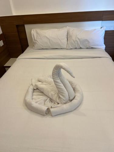 a towel animal is laying on a bed at Welcome Hotels in Trichūr