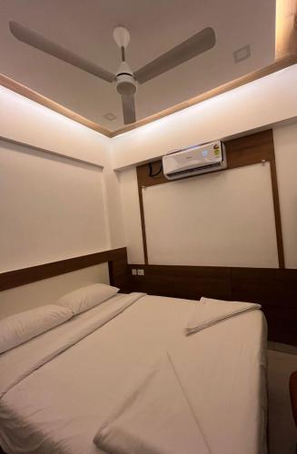 Cama en habitación con ventilador de techo en Welcome Hotels en Trichūr