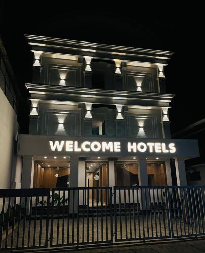 una señal de hotel de bienvenida en la parte delantera de un edificio en Welcome Hotels en Trichūr