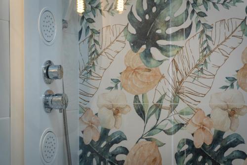 La salle de bains est pourvue d'une douche et de papier peint à fleurs. dans l'établissement Nice cozy townhouse with views, à Mijas