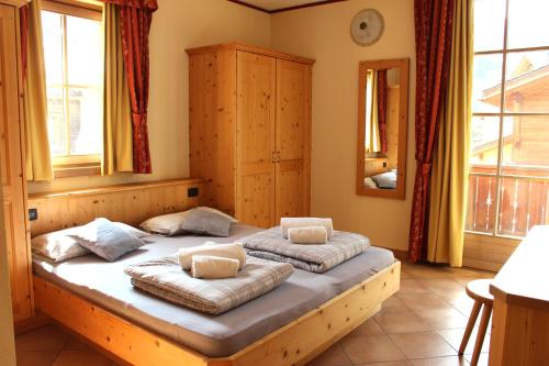 a bedroom with two beds in a room with windows at Appartamento Joemy in Livigno