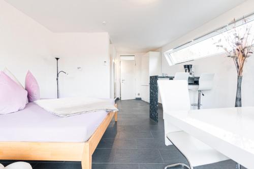 Habitación blanca con cama y ventana en Brenzapartments Königsbronn 1 und 2, en Königsbronn