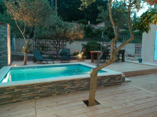 une piscine avec un arbre à côté d'une terrasse dans l'établissement Villa en Provence Summer Vibes, à Puget-Ville