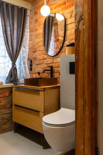 a bathroom with a toilet and a sink and a mirror at Reszel Art House in Reszel