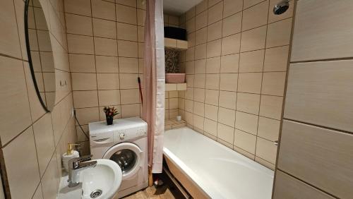 uma casa de banho com uma máquina de lavar roupa e um lavatório em Smile Appartment em Tartu