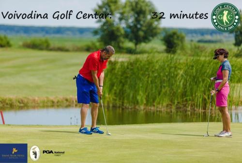 two people playing golf on a golf course at Eagles Court - Orlovski Vrt in Staji°evo