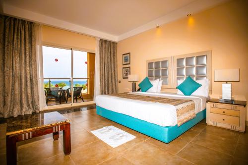 a bedroom with a large bed with a view of the ocean at Tropitel Sahl Hasheesh in Hurghada