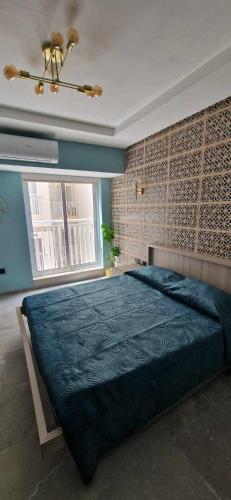 a bedroom with a large bed with a blue blanket at B8 Seaside Luxury Rooms with private bathroom - dining area shared in St Paul's Bay