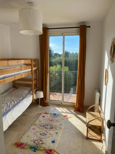 - une chambre avec des lits superposés et une porte coulissante en verre dans l'établissement Villa Grimaud - au calme sur Golf, et vue mer sur le Golfe de Saint-Tropez, à Grimaud