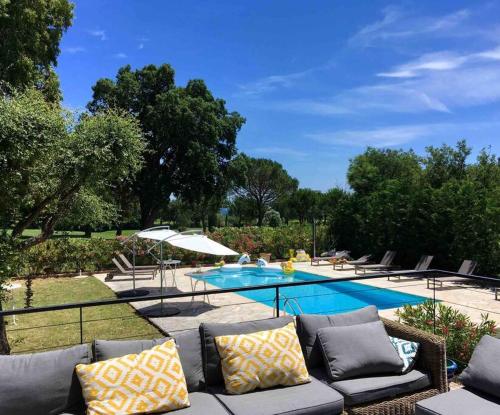 - un canapé installé en face de la piscine dans l'établissement Villa Grimaud - au calme sur Golf, et vue mer sur le Golfe de Saint-Tropez, à Grimaud