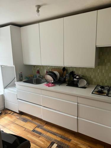 a kitchen with white cabinets and a sink at 1 bed and breakfast by the Thames in Thamesmead