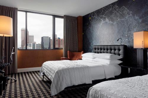 a hotel room with two beds and a large window at Le Méridien Charlotte in Charlotte