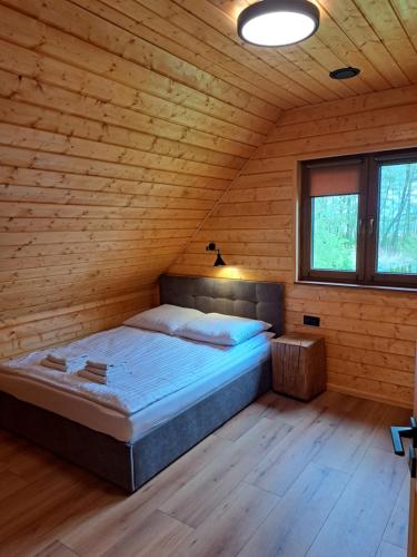 una camera da letto con letto in una camera in legno di Kamienica House 9 a Wągrowiec