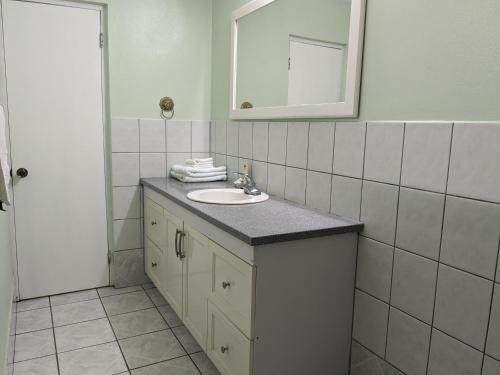 a bathroom with a sink and a mirror at 2BR 1BA, Modern Apartment with Aircon and Pool House Access in Harris