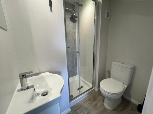 La salle de bains est pourvue de toilettes, d'un lavabo et d'une douche. dans l'établissement We House One - Birmingham, à Birmingham