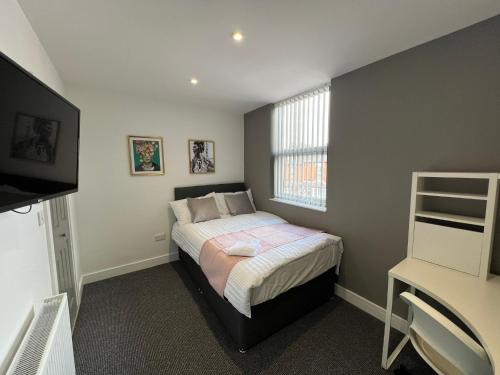 a small bedroom with a bed with a window at We House One - Birmingham in Birmingham