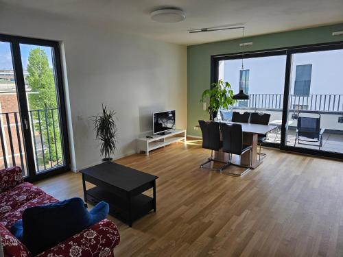 a living room with a table and chairs and a dining room at 3 rooms 2 bathrooms 2 toilets new apartment center of Düsseldorf underground parking space contactless self check-in in Düsseldorf