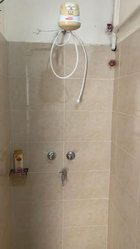 a shower with a shower head in a bathroom at The Cozy Home in Nairobi