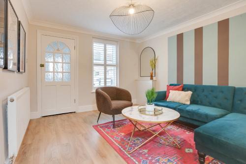 a living room with a blue couch and a table at Ann’s Place - 2 Bed House Central Romford - Free Parking & Garden in Romford
