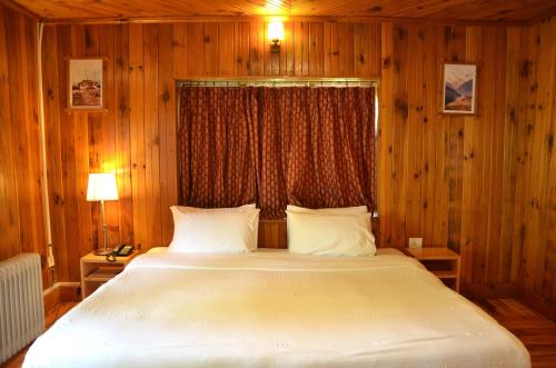 a bedroom with a large bed and a window at Sinchula Villa in Paro
