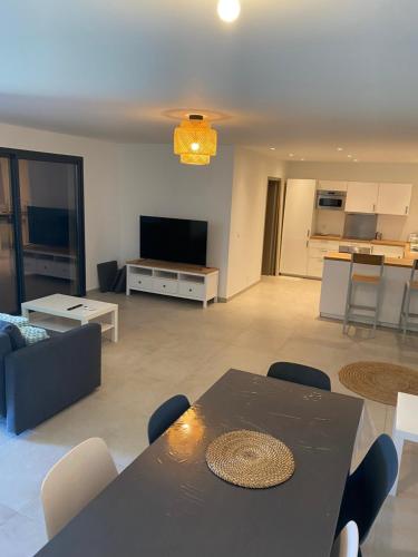 Il comprend un salon avec une table à manger et une cuisine. dans l'établissement Villa CALLINAJO , à 1 min de la plage LOZARI, à Belgodère