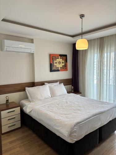 a bedroom with a large bed and a window at Upart Home in Mersin