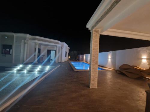 a view of a swimming pool at night at Belle villa Zarzis in Zarzis