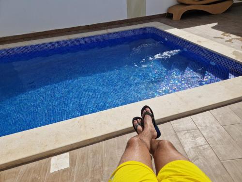 a man laying on the floor next to a swimming pool at Belle villa Zarzis in Zarzis