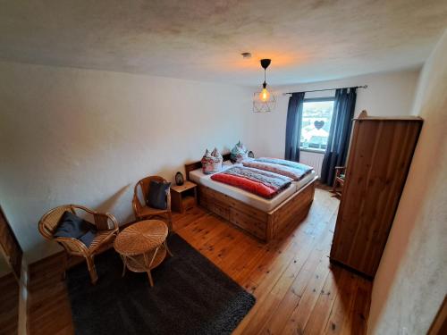 a bedroom with a bed and chairs and a window at Zum Jandel in Boppard