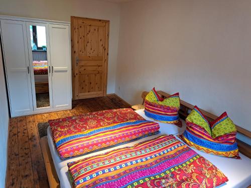 a room with two beds with colorful blankets and pillows at Zum Jandel in Boppard