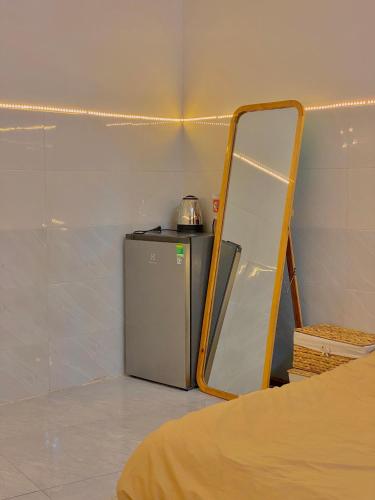 a room with a small refrigerator and a mirror at Homestay Tuyết Trinh in Nha Trang