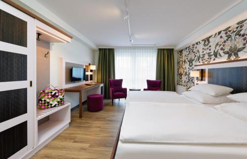 a hotel room with two beds and a desk at Hotel Sellhorn, Ringhotel Hanstedt in Hanstedt