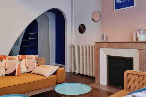 un salon avec un canapé et une cheminée dans l'établissement Art déco-cooning, à Autun