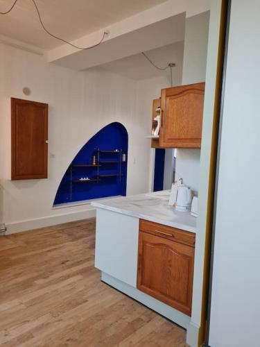 une cuisine avec un comptoir blanc et une fenêtre bleue dans l'établissement Art déco-cooning, à Autun