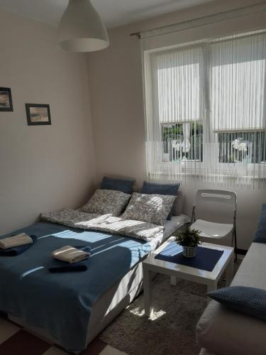 a bedroom with a bed and a table and a couch at Villa Spokojna 26 in Mielno