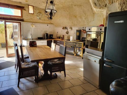 une cuisine avec une table en bois et un réfrigérateur dans l'établissement La grotte, à Bourré